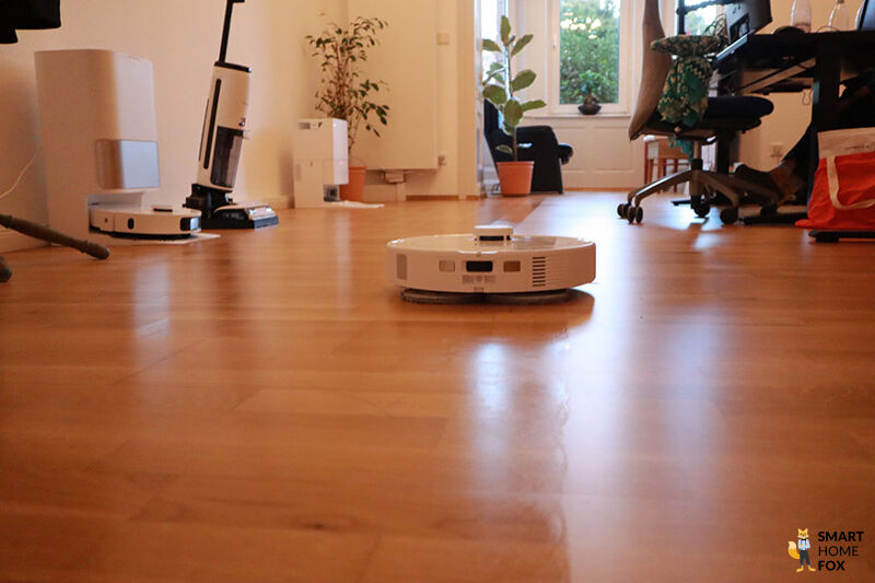 Der Roborock Q Revo MaxV wischt den Boden im Wohnzimmer.